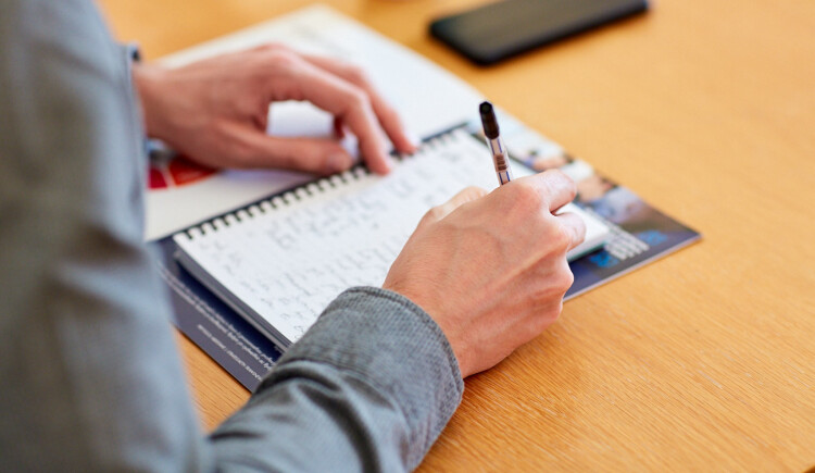 Close up of someone writing in a notebook